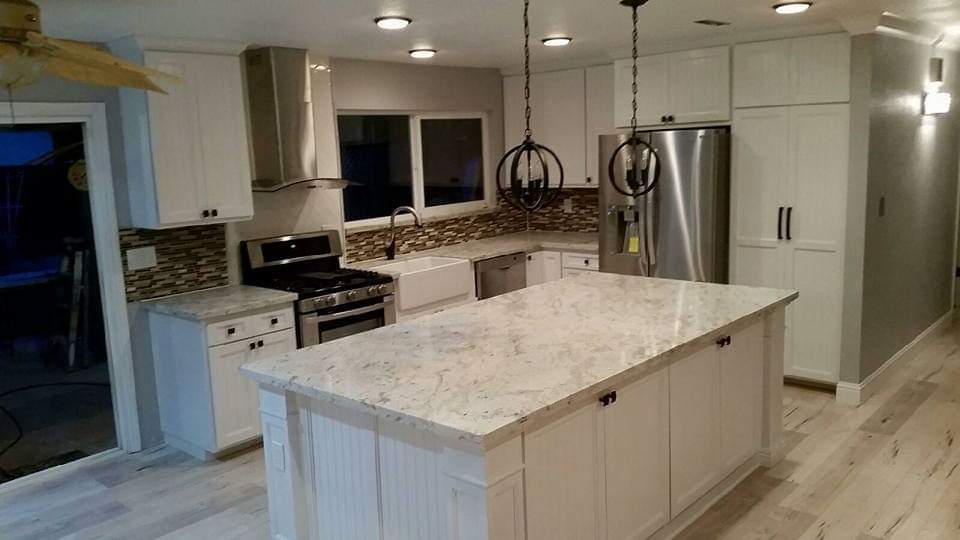 Granite Island Kitchen — White Cabinetry & Pendant Lights