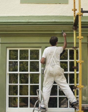 Painter decorating a house exterior.